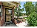 Close-up of the home's entrance, featuring a secure screen door and landscaped garden at 2461 Niagara St, Denver, CO 80207