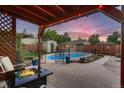 Inviting backyard featuring a swimming pool, fire pit, pergola, and beautifully landscaped yard at 4329 S Clarkson St, Englewood, CO 80113