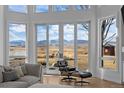Living room with wall-to-wall windows showcasing mountain views, comfortable seating, and a fireplace at 7401 Deerfield Rd, Longmont, CO 80503