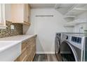 Laundry room features washer/dryer hookups, cabinets, and convenient wire shelving at 1202 S Troy St, Aurora, CO 80012