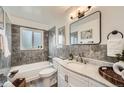 Elegant bathroom with marble countertop, gray tiled shower, and modern fixtures at 1649 Lima St, Aurora, CO 80010