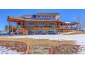 Luxury home with large deck, stone accents, and a landscaped yard at 934 S Perry Park Rd, Sedalia, CO 80135