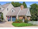 Charming home exterior with a well-manicured lawn, colorful flower beds, a blue garage door and mature landscaping at 7001 S Newport St, Centennial, CO 80112