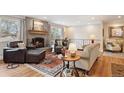 Cozy living room features a brick fireplace, wood floors, and comfortable seating at 2588 S Flower Ct, Lakewood, CO 80227