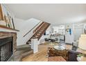 Open living area with a fireplace, staircase, and a view into the kitchen at 1941 Newland Ct, Lakewood, CO 80214