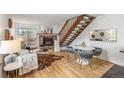 Bright living room with a fireplace, wood floors, and stairs leading to the second floor at 1941 Newland Ct, Lakewood, CO 80214