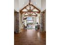 Elegant living room with soaring ceilings, exposed wood beams, stone columns, and a large window offering scenic views at 1052 Country Club Estates Dr, Castle Rock, CO 80108