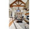 Spacious living room featuring a stone fireplace, exposed beams, and ample seating for relaxation and entertainment at 1052 Country Club Estates Dr, Castle Rock, CO 80108