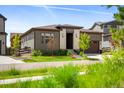 Charming exterior with mature trees, green grass, and well maintained landscaping at 6530 Barnstead Dr, Castle Pines, CO 80108
