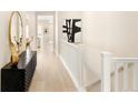 Bright hallway with modern decor, hardwood floors, and a staircase leading to the upper level at 6530 Barnstead Dr, Castle Pines, CO 80108