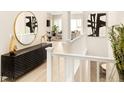 Bright hallway with decor, hardwood floors, and view of the living room at 6530 Barnstead Dr, Castle Pines, CO 80108