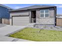 Single-Gathering home with a two-car garage, green lawn, and stylish gray exterior, under a clear blue sky at 13437 Waterthrush St, Parker, CO 80134