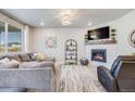 Cozy living room with a fireplace, plush seating, and a large window with natural light at 13437 Waterthrush St, Parker, CO 80134