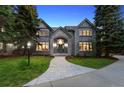 Charming home with stone facade, arched entryway, and manicured front lawn with mature trees at 5390 S Boston St, Greenwood Village, CO 80111