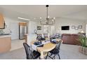 Eat-in kitchen open to the living room, dining area with stylish chandelier and modern decor at 16773 W 61St Ln, Arvada, CO 80403
