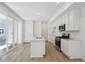 Modern kitchen featuring white cabinets, stainless steel appliances, and a center island with sink at 1366 Penner Dr, Erie, CO 80026