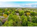 Expansive aerial view showcasing the neighborhood, mature trees, surrounding community, and nearby open space at 9540 E Grand Pl, Greenwood Village, CO 80111