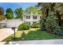 Charming two-story home with white exterior, well-manicured lawn, mature trees, and inviting curb appeal at 9540 E Grand Pl, Greenwood Village, CO 80111