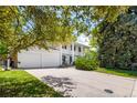 Two-story home featuring a two car garage, mature trees, front yard and a large drive way at 9540 E Grand Pl, Greenwood Village, CO 80111