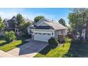 Charming single-Gathering home with a two-car garage, lush green lawn, and mature trees under a bright, sunny sky at 15926 Butterwort Cir, Parker, CO 80134