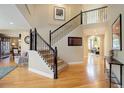 Inviting foyer featuring a staircase with wrought iron spindles and gleaming hardwood floors at 10914 W Coco Pl, Littleton, CO 80127