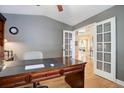 Bright home office with french doors, a large desk, and hardwood floors at 10914 W Coco Pl, Littleton, CO 80127
