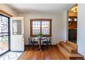 Sun-drenched entryway showcases a stained glass door, wood-framed window, and a quaint table set for two at 1836 S Grant St, Denver, CO 80210