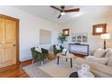 An airy living room with a ceiling fan, two arm chairs, and a cream colored couch at 1836 S Grant St, Denver, CO 80210