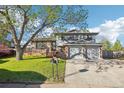 Charming two-story home with a lush front yard and a two-car garage on a sunny day at 4933 S Xenon Ct, Morrison, CO 80465