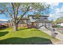 Charming two-story home with a lush front yard and a two-car garage on a sunny day at 4933 S Xenon Ct, Morrison, CO 80465