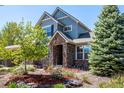 Inviting home entrance with a stone archway, mature trees, and colorful landscaping creating a warm welcome at 11857 S Saunter Ln, Parker, CO 80138