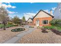 Attractive brick home with inviting walkway, rock garden, mature landscaping, and detached garage at 1748 S Logan St, Denver, CO 80210