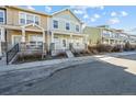 Street view of two-story townhome with a cozy front porch, landscaping, and adjacent unit at 15612 E 96Th Way # 20H, Commerce City, CO 80022