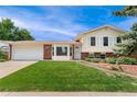 Charming two-story home with a well-manicured lawn and attached two-car garage at 8475 W 74Th Dr, Arvada, CO 80005