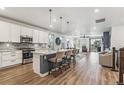 Open concept kitchen with island, stainless steel appliances, and hardwood floors at 7870 Slate River St, Littleton, CO 80125