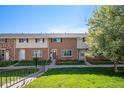 Charming brick townhome featuring a well-maintained lawn and landscaped front yard at 9272 E Mansfield Ave, Denver, CO 80237