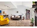 Bright living room with neutral walls, cozy carpeting, and a statement yellow arm chair at 12142 Bannock Cir # B, Denver, CO 80234