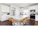 Bright kitchen featuring stainless steel appliances, white cabinets, large island with seating, and modern finishes at 21925 E 44Th Pl, Aurora, CO 80019