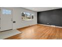 Bright living room featuring hardwood floors, a front door entrance, and a large window at 2354 S Stuart St, Denver, CO 80219