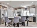 Modern kitchen featuring stainless steel appliances, a center island with seating, and bright lighting at 10639 Worchester Dr, Commerce City, CO 80022