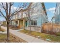 Charming two-story home with a welcoming teal-colored front door and cozy yard at 2212 Tamarac St, Denver, CO 80238