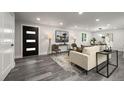 A bright living room featuring modern finishes and neutral decor, and a stylish front door at 9591 W Florida Pl, Lakewood, CO 80232