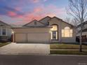 Beautiful home boasting a two-car garage, arched entryway, landscaped front yard, and a picturesque setting at dusk at 5541 S Eaton St, Littleton, CO 80123