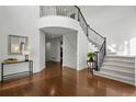 Grand two-story foyer featuring gleaming hardwood floors, elegant staircase, and abundant natural light at 6577 Esperanza Dr, Castle Pines, CO 80108