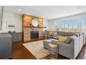 Inviting living room featuring a stone fireplace, plush sectional sofa, and hardwood flooring at 6577 Esperanza Dr, Castle Pines, CO 80108