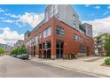 Modern building exterior showcasing red brick architecture, ample windows, and urban street view at 2955 Inca St # 2Q, Denver, CO 80202