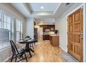 Bright dining area features hardwood floors, a dining table, and a view of the kitchen with cherry cabinets at 10148 E 29Th Dr, Denver, CO 80238