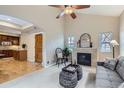 Living room features fireplace, high ceilings, neutral decor, and hardwood floors leading to the kitchen at 10148 E 29Th Dr, Denver, CO 80238