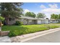 A well-kept single-story home featuring a lush green lawn and mature trees in a friendly neighborhood at 1742 S Forest St, Denver, CO 80222