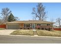 Charming ranch-style home featuring a brick facade, a well-manicured lawn, and an attached garage with an inviting curb appeal at 2822 S Zenobia St, Denver, CO 80236